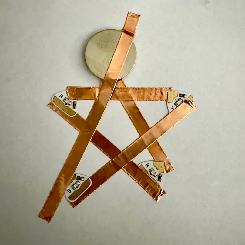 I tried out a multi-light star design! It didn't work though... I wasn't sure if it was because the tape was touching before reaching the battery, I stacked the tape, or I just placed the LEDs wrong.