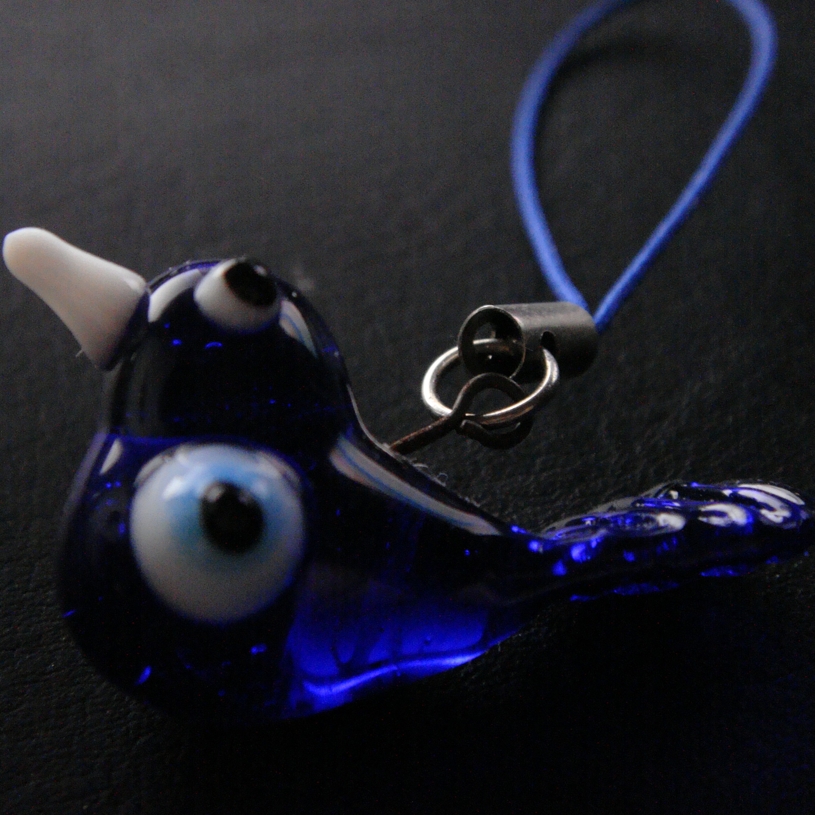 A glass bird with its eyes and wings replaced with evil eyes.
