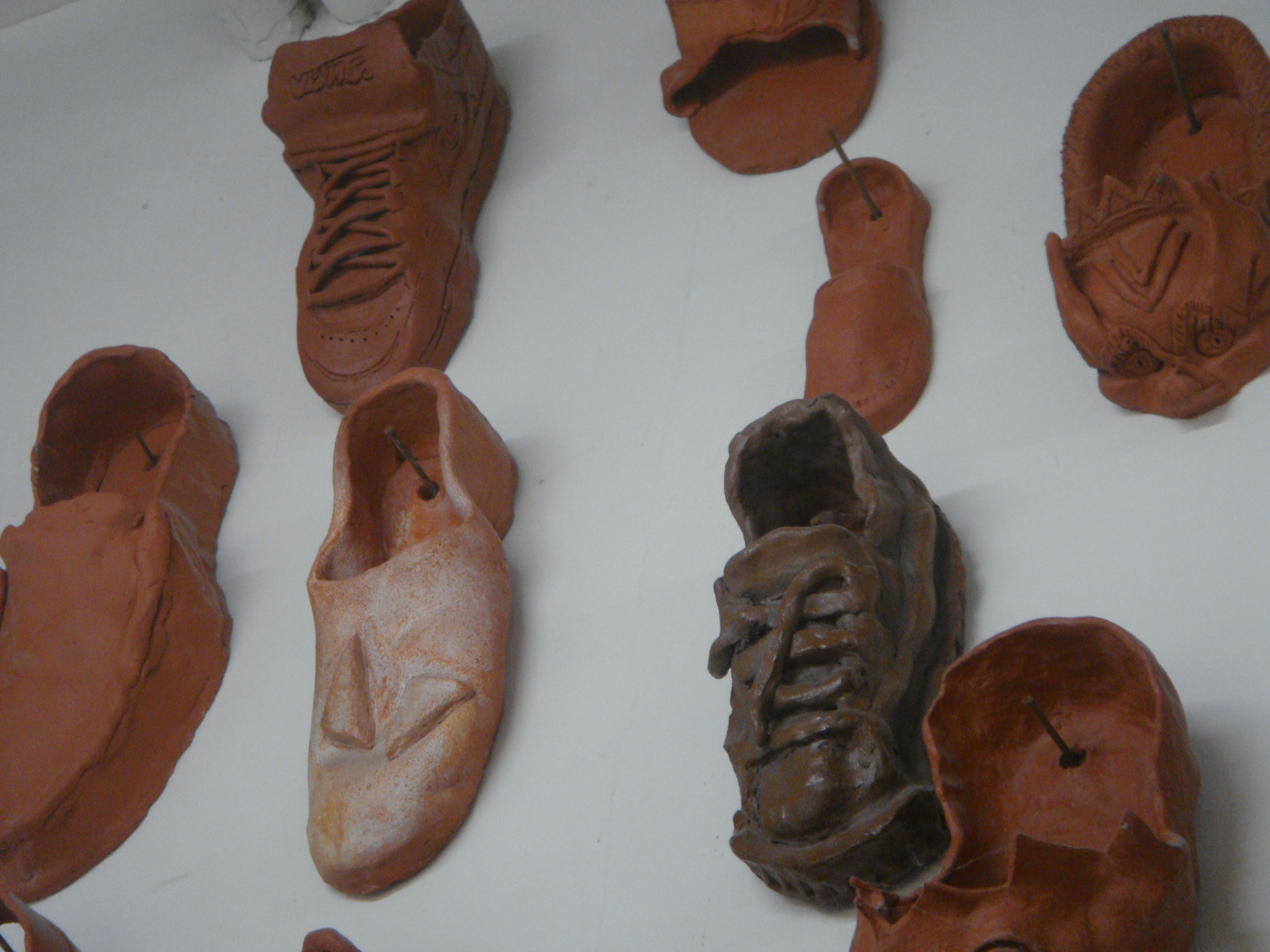 Ceramic shoes nailed into the walls of the Crafts Building. Students in Craft and Design, Ceramics, made them.